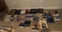 Full lot of 19 books laid out on a carpeted floor displaying covers focused on historical ships and naval themes.