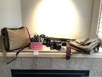 Overview of cameras, lenses, tripods, flash, and bags arranged on a counter.