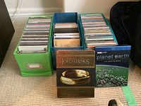 Photo showing three containers full of music CDs along with the Lord of the Rings Extended Edition DVD and Planet Earth DVD.