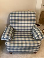Front view of the blue and white plaid upholstered armchair showing seat cushion, armrests, and backrest.