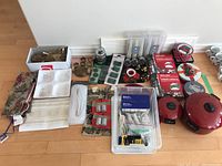 View of the full lot including ribbons, ornament hooks, candles, and two red cooking pots on floor