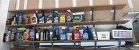Wide shot of garage shelves displaying various cleaning, lubricants, pest control, and car maintenance spray bottles and containers.
