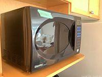 Photo of black Danby Designer microwave oven, showing front and side view with door closed.