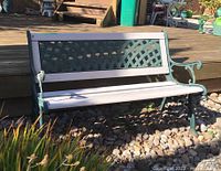 Front view of outdoor bench showing iron lattice backrest and wooden seat slats with paint wear.