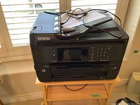 Front view of Epson WorkForce WF-7720 printer on wooden stand