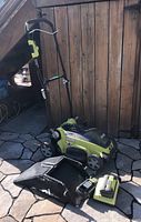 Side view of mower, grass bag, charger, and batteries