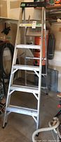 Front view of the aluminum step ladder showing the step layout and black top cap.