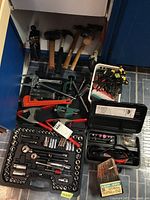 Overall view showing socket set, clamps, rotary tool, clamps baskets, hammers, mallet, and various hand tools laid on floor