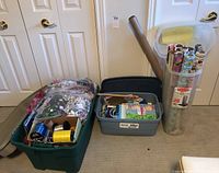 Full view of all contents packed in two storage totes and one tall clear container with multiple rolls of wrapping paper and a cardboard tube.