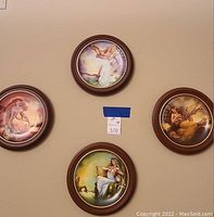 Four framed circular art plates representing the four ancient elements mounted on a beige wall.