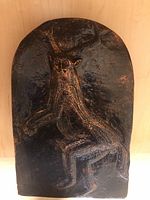 Photo showing black Celtic creature plaque with copper highlights and texture.