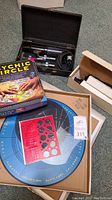 Lot contents with all items displayed: two violet ray wand cases with wands and electrodes, The Psychic Circle game box and circular game board, Original Astrometer game board and boxed components.