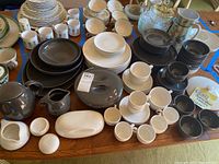 Overview of grey and white china pieces laid out on table