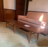 Long view of Lane Modern coffee table in room, showing full length and tapered legs.