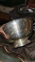 Close-up side view of the silver plated bowl showing engraving and patina needing cleaning.