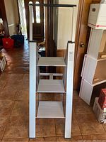 Closed view of the Frontgate collapsible ladder showing four wide steps and aluminum side rails.