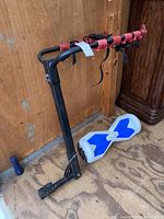 Bike rack standing showing red securing straps and attached hoverboard at base.