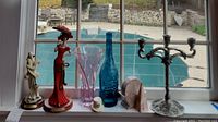 Photo showing two La Verona ceramic dolls, decorative glass vases and bottles, marble-like pyramid and coaster set, and metal candle holder