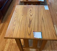 Top view of wooden side table showing wood grain pattern and scratches.