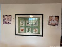 Three kitchen-themed wall art pieces on a white wall arranged side-by-side. The center piece is a rectangular vegetable garden print with black frame; the two smaller square prints on each side depict chefs and kitchen items with checkered borders.