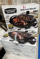 Five boxed Granitestone Diamond 12-inch electric skillets stacked, showing front and side views of packaging and skillet images.