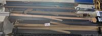 Photo showing stack of nine rectangular Lithonia Lighting LED wrap lights in cardboard boxes on a black metal shelf.