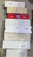 Seven long cardboard boxes stacked containing sports trading cards