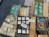 Overview of several boxed and bagged store inventory items including push pins, foil seals, magnets