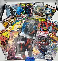 Full view of all 15 comic books laid out showing variety of Marvel and DC titles, character artwork and cover designs.