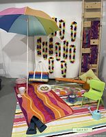 Full lot view showing beach umbrella, towels, leis, flippers, chair, tote bag, decorative and serving items.