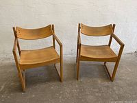 Front view of two sling-back chairs side by side on concrete floor
