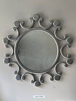 Front view of the silver burst decorative round mirror showing the circular patterns on the frame