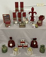 Full view of all items including boxed diffusers, reed candles, fleur de lis, stationary set, drink coasters, candle holders, and ornaments.