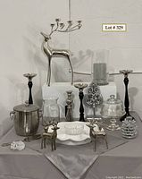 Wide shot showing entire lot including large silver reindeer with candle holders in antlers, smaller reindeer, candlesticks, ice bucket, glassware, serving pieces