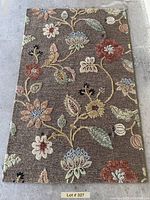 Full view of rug showing overall floral vine design and earth tone colors.