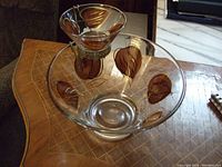 Glass chip and dip bowl set featuring leaf motifs on a table