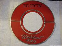 Front view of circular red metal breather cover decal with Buick Wildcat 445 markings.