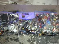 Three large resealable plastic bags filled with assorted electronic parts placed on a table.