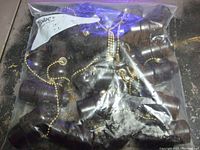 Large resealable bag containing multiple vintage pull chain lamp sockets with dark bakelite cases and brass pull chains.