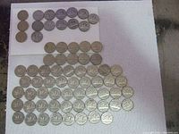 Lot of 71 Canadian nickels laid out on a white paper towel showing front and back designs. Includes older King George V nickels at top left and numerous King George VI nickels spreading out below.