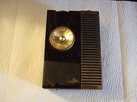 Top front view of the black and gold plated vintage radio showing the tuning dial and speaker grille.