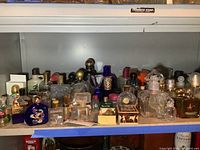 Shelf overview showing assorted perfume and cologne bottles on metal rack