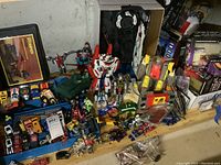 Shelf overview showing multiple die-cast vehicles, Transformers figures and storage cases