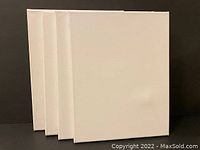 Four white canvases standing vertically showing front surfaces.