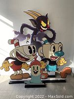 Front view of all four Cuphead characters standing together as display stand-ups.