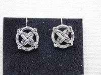 Front view showing both round Celtic knot earrings with wire hooks against a black background