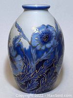 Front view of the oval porcelain vase showing cobalt blue flowers and gold accented leaves on a white background.
