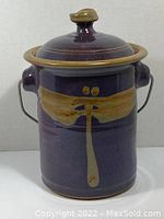 Front view of purple ceramic compost pail showing tan dragonfly design and lid.