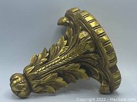 Side angle view showing detailed leaf motifs and rounded bottom finial.
