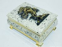 Photo showing full view of rectangular box with faux granite appearance, gold trim and feet, and raised Tree of Life on lid.